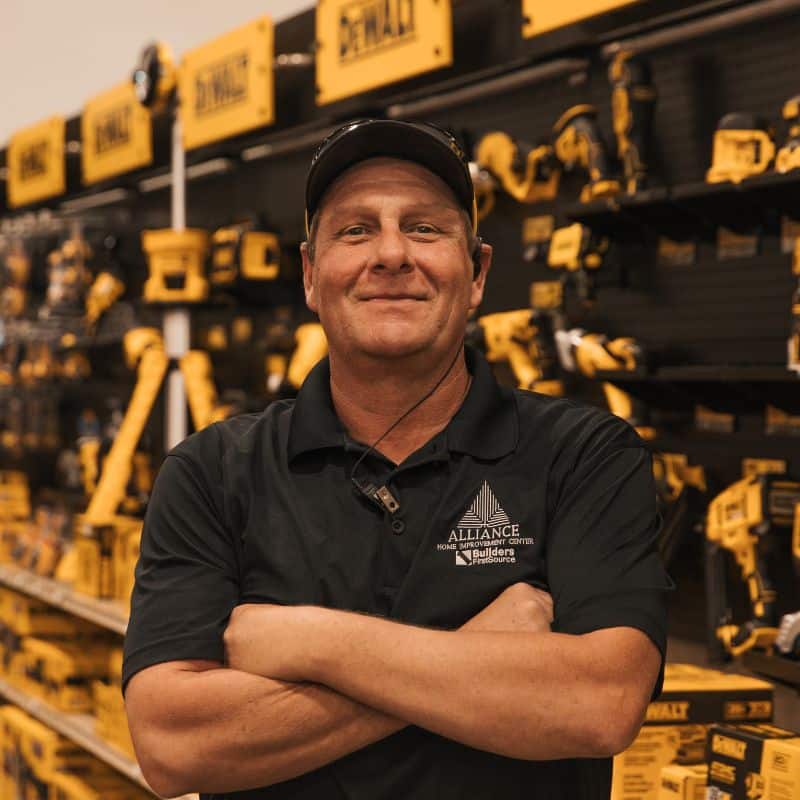 Employee Standing in Front of DeWalt Tool Wall