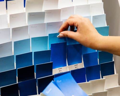 Woman Choosing from Different Blue Paint Swatches