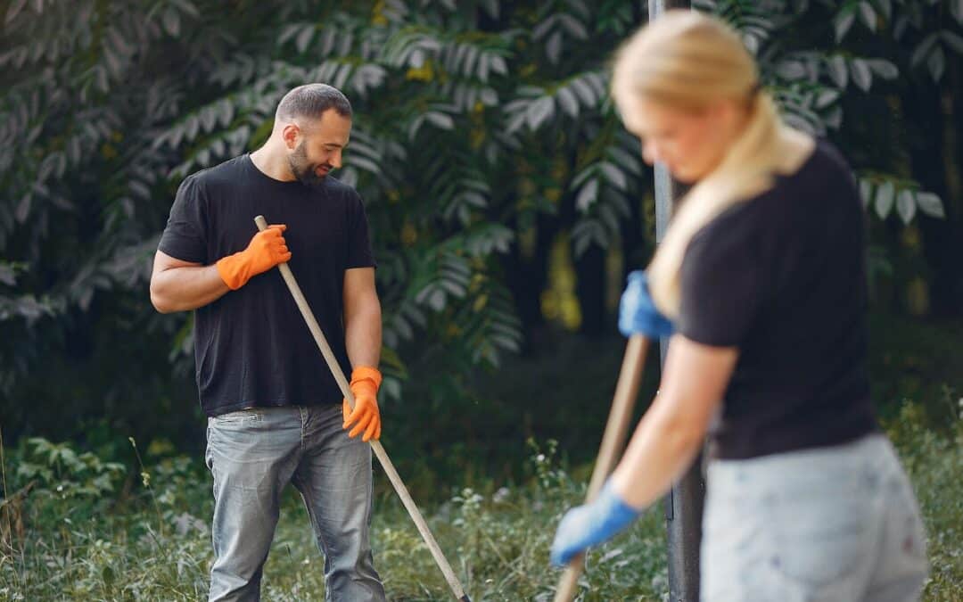 couple collects leaves and cleans their yard