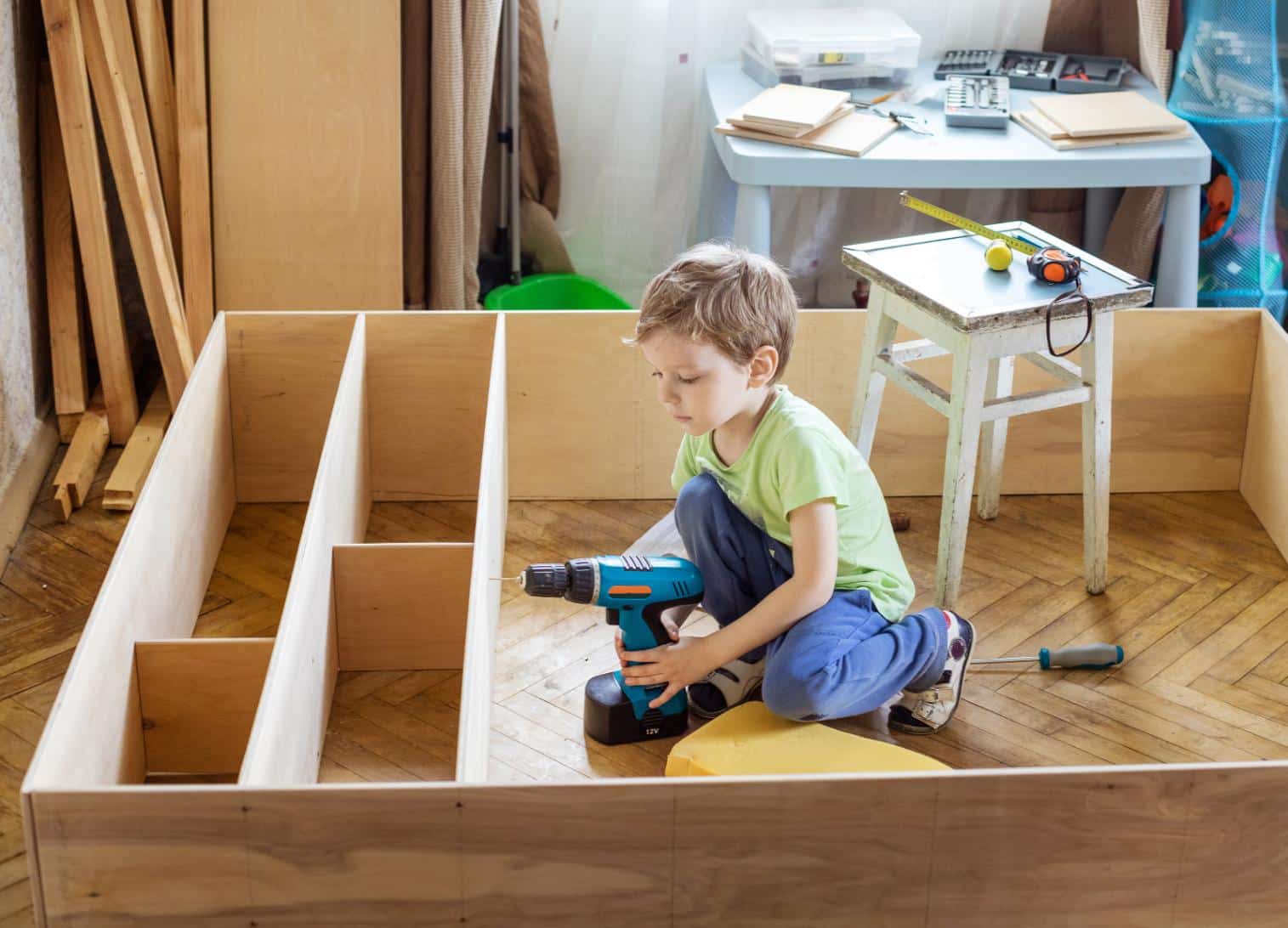 young-boy-holding-screwdriver-while-sitting-on-flo-2023-11-27-04-51-24-utc